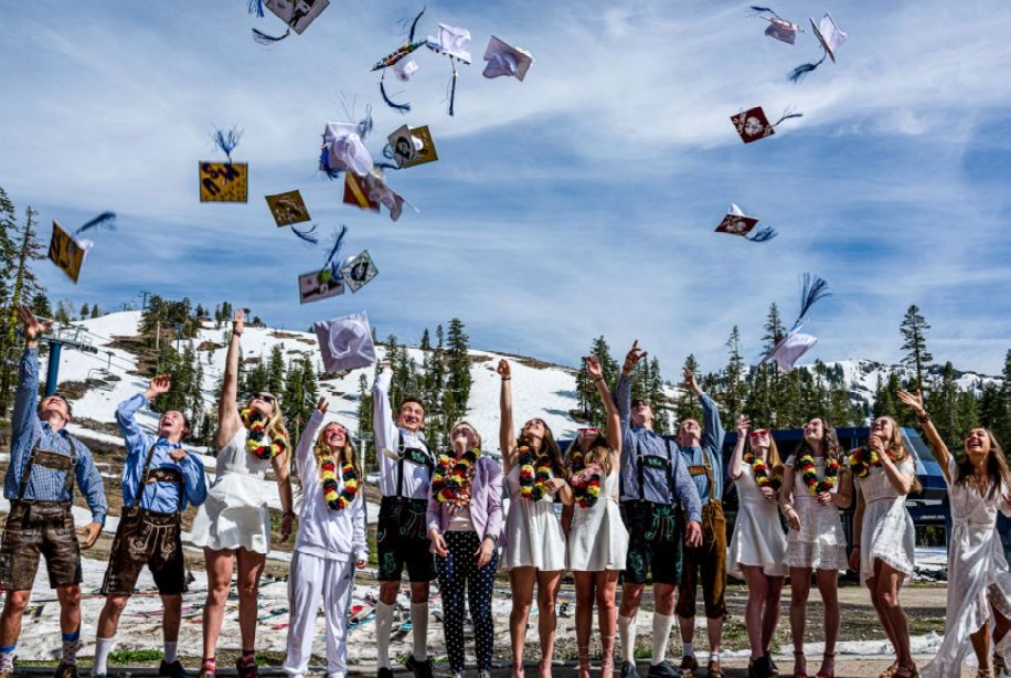Sugar Bowl Academy graduates celebrating outdoors, tossing caps into a blue Sierra sky.